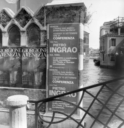 Blick auf einen Kanal in Venedig mit Plakaten, die eine Giorgione-Ausstellung und ein politisches Manifest im Vordergrund bewerben von Italian Photographer