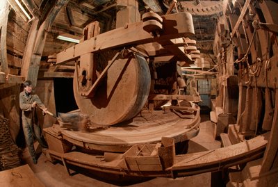 Ein Mann mahlt Kakaobohnenschalen zu Tierfutter in einer 100 Jahre alten Mühle. Ooievaar-Mühle von James L Stanfield