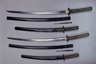 Oben: ein Katana, japanisches Schwert und seine Scheide, Wakizashi, japanisches Kurzschwert in seiner Scheide, kleiner Kokatawa-Dolch in derselben Scheide. Alle drei aus dem 18. Jahrhundert. Die unteren aus dem 17. Jahrhundert von Japanese School