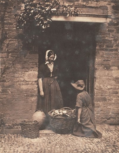 Zwei Frauen, eine kniend und eine stehend, schauen in einen Korb voller Gemüse von John Dillwyn Llewelyn