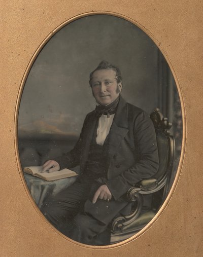 Sitzender Mann zeigt auf eine Passage in einem offenen Buch, 1850er von John Jabez Edwin Mayall
