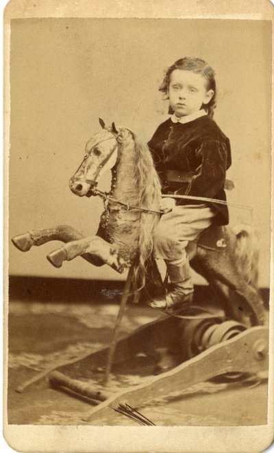 Junge mit Peitsche auf Schaukelpferd von John McCaffrey