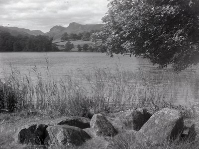 Blick über Loughrigg Tarn, im Vordergrund einige Steine im Boden von Joseph Hardman