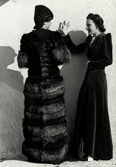 Zwei Modelle präsentieren Kreationen des italienischen Modehauses "Dragoni". Ein Modell von hinten trägt einen Silberfuchsmantel. Das andere Modell trägt einen langen Samtmantel. von Luis Bogino