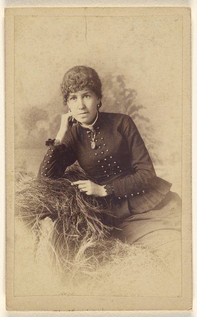[Unidentifizierte Frau sitzt mit Hand auf der Wange, auf einem Heuhaufen posierend] von Miller and Company