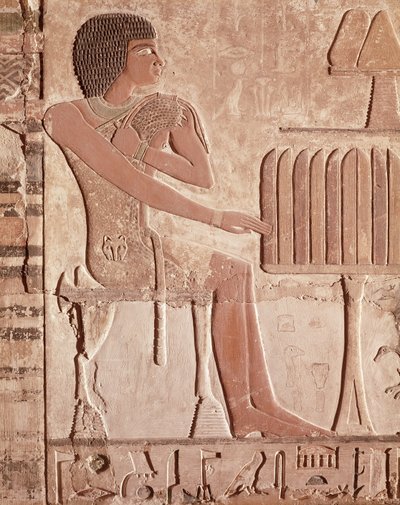 Relief, das den Verstorbenen zeigt, wie er vor einem Opfertisch mit Brot sitzt von Old Kingdom Egyptian
