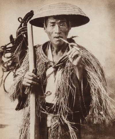 Japanischer Kuli (Landarbeiter) mit einem Hut, um sich vor starkem Regen in den Reisfeldern zu schützen (s/w Foto) von Photographer Japanese