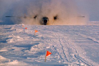 In Rauch gehüllt, landet ein Versorgungsflugzeug auf der markierten Landebahn von Arlis II von Ted Spiegel