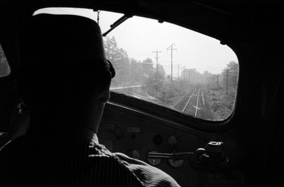 Blick auf die Gleise aus dem Führerstand einer Diesellokomotive mit dem Lokführer, Pazifischer Nordwesten von Ted Spiegel