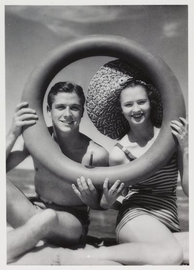 Mann und Frau schauen durch einen Gummiring am Strand, um 1935 von Unbekannt