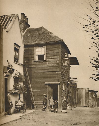 Alte Häuser in Highgate, aus deren Türöffnungen die Dorfbewohner die Kutschen vorbeifahren sahen, um 1935 von Unbekannt