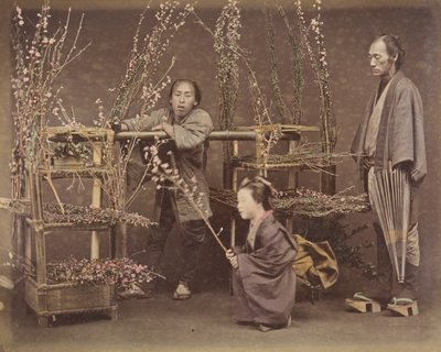 [Zwei japanische Männer und eine japanische Frau posieren mit blühenden Zweigen], 1870er Jahre von Unbekannt