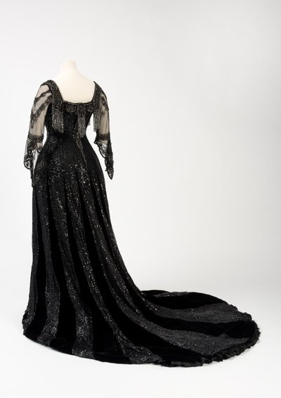 Schwarzes Abendkleid, getragen von Königin Alexandra, mit Perlen- und Paillettenverzierung und der Unterschrift von Königin Alexandra, hergestellt von Barolet of Knightsbridge, London 1908-1910 von Unbekannt