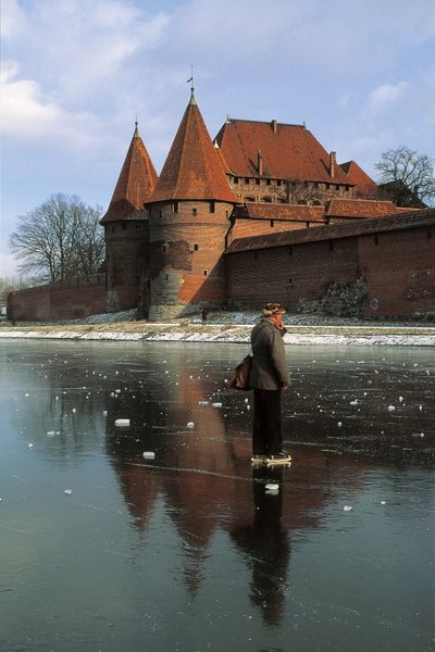 Seitenprofil eines Mannes, der auf einem zugefrorenen Fluss vor einer Burg steht, Nogat-Fluss, Marienburg, Pommern, Polen von Benjamin Baud