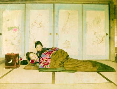 Auf einem Futon liegend. Zwei japanische Frauen liegen auf einem traditionellen Futon auf dem Boden. Japan, um 1910. von Unknown photographer