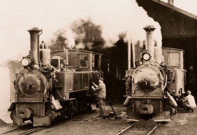 Zwei Dampflokomotiven werden von zwei Arbeitern gewartet von Unknown photographer