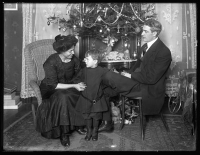 Dan Seymour und Familie in informeller Pose, sitzend unter einem Weihnachtsbaum, Weihnachten 1912 von William Davis Hassler