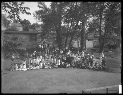 Große Gruppe von Kindern für ein Gruppenporträt auf einem unbekannten Spielplatz, ca. 1910 von William Davis Hassler