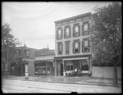 Sieben Kinder posieren vor einer nicht identifizierten Filiale der Queens Borough Public Library, New York, ca. 1910 von William Davis Hassler