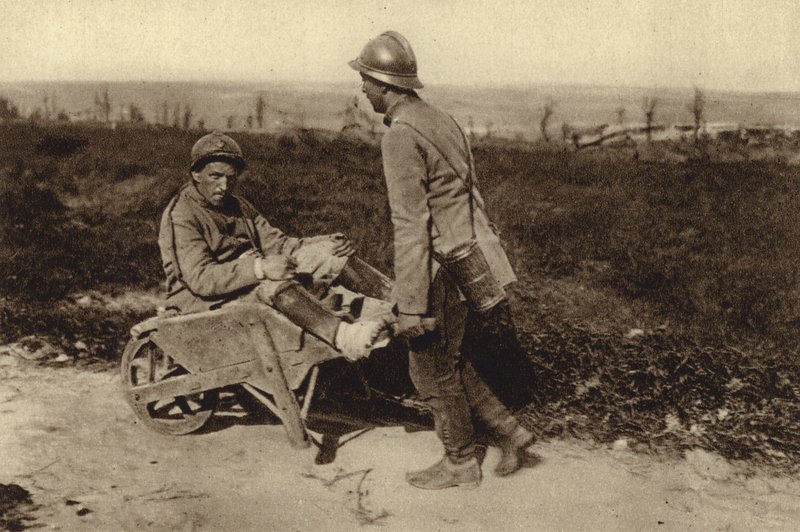 Gefangener französischer Soldat transportiert seinen verwundeten Kameraden in einer Schubkarre, Erster Weltkrieg von Photographer German