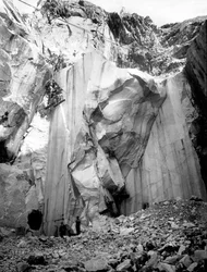 Steinbrucharbeiter bei der Arbeit an einer steilen Wand eines Marmorsteinbruchs in den Apuanischen Alpen, Toskana.