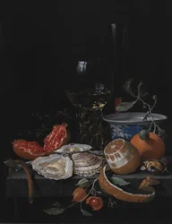 Austern, Obst und ein Weinglas auf einem Steintisch