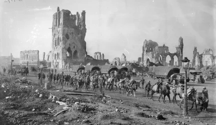 Eine unbekannte australische Maschinengewehrabteilung mit Packpferden passiert die Ruinen der Tuchhalle. Beachten Sie die im Hintergrund geparkten Lastwagen, 19. Oktober 1917