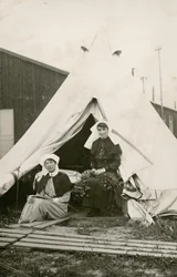 Schwester Eleanor Wibmer Jeffries und Schwester Nellie Constance Morrice (rechts) vor ihrem Zelt im 3. Australischen Allgemeinen Krankenhaus mit Blumen, die am Ufer der Somme gepflückt wurden, ca. Juni 1917