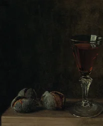 Ein Glas Wein mit Walnüssen auf einem Tisch