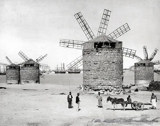 Windmühlen am Mittelmeer in Alexandria, Ägypten. Im Vordergrund posieren einige Ägypter mit einem kleinen Wagen