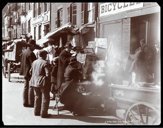 Ansicht von Straßenverkäufern, darunter einer, der fotografische Ansichten exotischer Orte in einer Guckkasten zeigt, in der Bayard Street, New York, 1898 (Silbergelatineabzug)