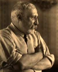 Profilporträt des Malers Arturo Rietti mit verschränkten Armen
