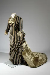 Abendkleid, ca.1884 (seitliche schräge Ansicht). Seidensatin und geschnittener Samt, Spitze, Seidenfadenquasten und Fransen. Charles Frederick Worth, Frankreich.