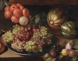 Weiße und rote Trauben auf einem Zinnteller, eine Zwiebelkette, zwei Melonen und Feigen, alles auf einem Holztisch