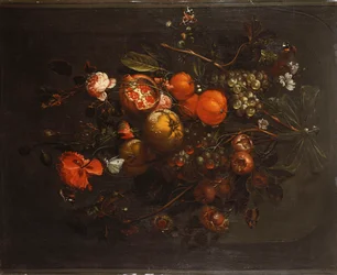 Ein Strauß aus Obst und Blumen, der an einem Nagel in einer Nische hängt