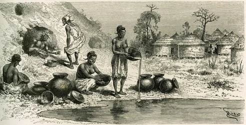 Frauen im Dorf Koumakhana waschen Gold, im Hintergrund suchen Männer in unterirdischen Galerien nach Gold. Gravur von Riou zur Illustration der Geschichte „Exploration du Haut-Niger (Haut-Niger)“ (heutiges Mali) von Kommandant Joseph Gallieni (1849-1916)