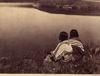 Eine ruhige Stunde - Ein Moment der Ruhe: Piegan-Indianer sitzen am Rand eines Gewässers. Foto aus Band 6 der Enzyklopädie von Edward S. Curtis (1868-1952) über die Indianer Nordamerikas, mit einem Vorwort von Theodore Roosevelt