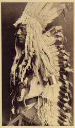Alter Mensch, Piegan. Junge Männer verpassen keine Gelegenheit, bei öffentlichen Festen die Kleidung ihrer Krieger-Väter zu tragen. Foto aus Band 6 der Enzyklopädie von Edward S. Curtis (1868-1952) über die Indianer Nordamerikas