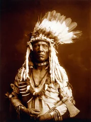 Weasel Tail, Piegan, mit einem Tomahawk, ca. 1900, Foto von Edward S. Curtis
