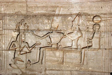 Ägyptische Antiquität: Relief, das Pharao Ramses II. vor den Gottheiten der thebanischen Triade, Amon, Mut und Khonsu darstellt; Totentempel von Ramses II., Ramesseum, Luxor, Ägypten