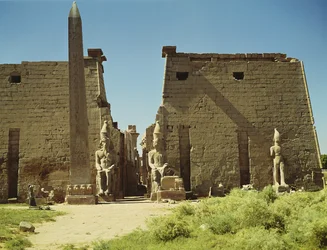 Fassade und erster Pylon mit zwei sitzenden Statuen von Ramses II und dem verbleibenden Obelisken