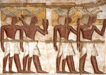 Ägyptische Antike: erster Hof, Detail der bemalten Reliefs, die eine Gruppe von Nubiern darstellen, die dem Pharao Opfergaben bringen. Totentempel von Ramses III. (1187-1156 v. Chr.). Luxor, Medinet Habu, Ägypten