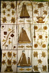 Ein gestepptes Bettüberwurf mit Segelschiffen und Blumen