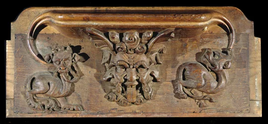 Eine Miserikordie, die drei menschliche Gesichter flankiert von Monstern darstellt, New College Chapel, Oxford, spätes 14. Jahrhundert