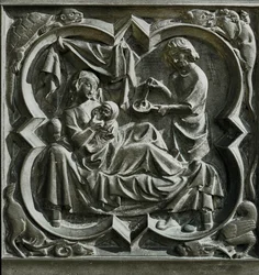 Adam bereitet Essen zu, während Eva im Bett ein Kind stillt