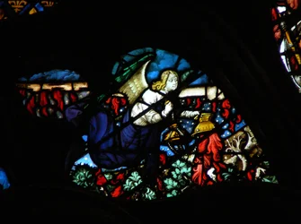 Das westliche Rosenfenster zeigt eine Szene aus dem Buch der Offenbarung: ein Engel, der das Altarfeuer nimmt und es auf die Erde wirft (8:5).