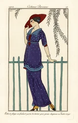 Frau im Strandkleid aus Foulard mit großen Punkten, roter Wildlederhut