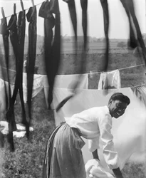 Eine junge afroamerikanische Frau hängt Wäsche zum Trocknen auf in Newport, Rhode Island, ca. 1902 (s/w Foto)