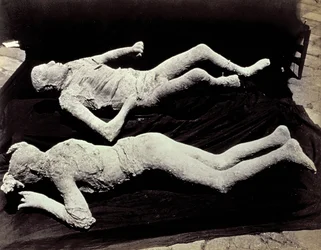 Zwei Abgüsse von menschlichen Figuren aus den Ausgrabungen von Pompeji. Die Exponate wurden auf schwarzem Tuch platziert, um sie zu fotografieren