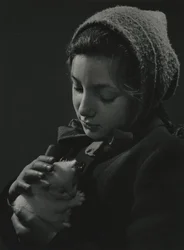 Mädchen hält ein weißes Kätzchen in den Armen. Frühe 1950er Jahre